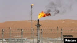 FILE - Flames are seen at the production facility of Saudi Aramco's Shaybah oilfield in the Empty Quarter, Saudi Arabia, May 22, 2018.