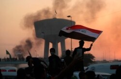 Anti-government protesters wave flags during a demonstration in Baghdad, Iraq, Oct. 2, 2019.