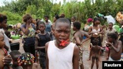 FILE - Congolese migrants expelled from Angola who crossed the border wash their clothes in a river near Kamako, Kasai province near the border with Angola in the Democratic Republic of Congo, Oct. 13, 2018. 