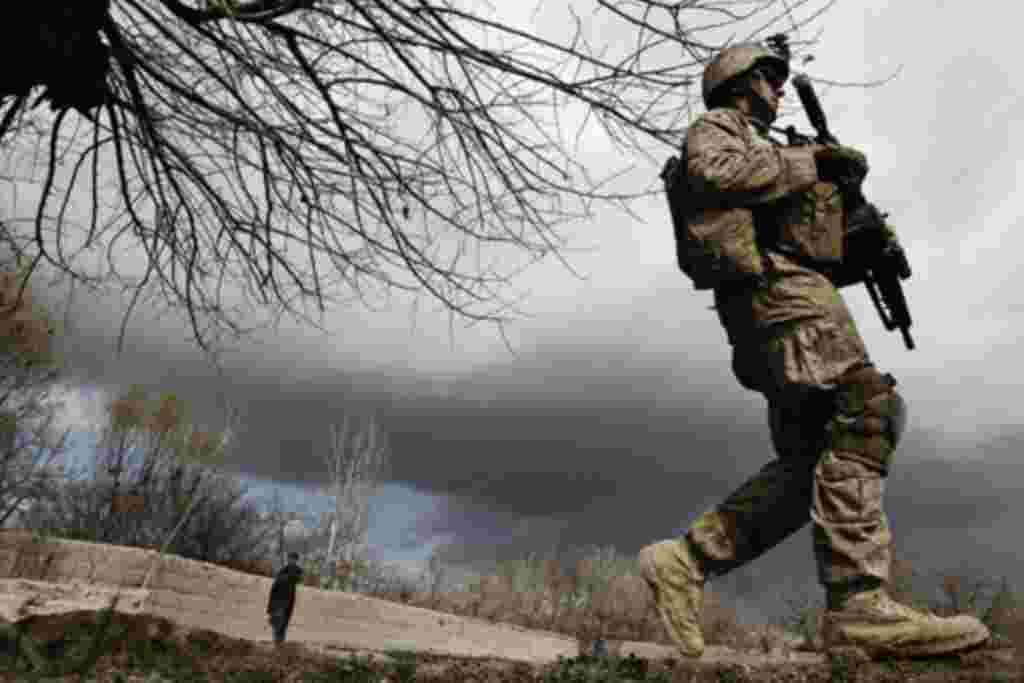 A U.S. Marine from the First Battalion Eighth Marines Alpha Company patrols near the town of Kunjak in southern Afghanistan's Helmand province February 23, 2011. REUTERS/Finbarr O'Reilly (AFGHANISTAN - Tags: CONFLICT MILITARY)