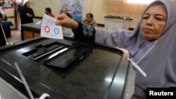 A woman casts her ballot in the final stage of a referendum on Egypt's new constitution in Cairo, Jan. 15, 2014. 