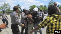 Polisi menahan demonstran Papua yang mengibarkan bendera Bintang Kejora (foto dok). Pemerintah mengimbau media tidak hanya menyoroti kasus-kasus HAM di Papua.