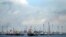 FILE - Ships are seen anchored in front of a refinery on Singapore's Bukom Island, July 6, 2014.