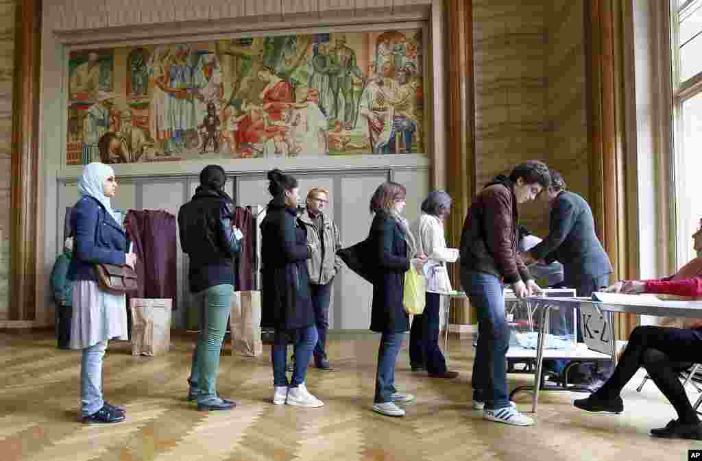 Residentes de Par&iacute;s hacen fila ante una mesa electoral. (AP)