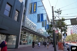 People walk along Market Street past the new IKEA store on its opening day in San Francisco, Wednesday, Aug. 23, 2023. (AP Photo/Eric Risberg)