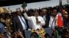 FILE - Opposition leader Raila Odinga, center, accompanied by lawyer Miguna Miguna, center-left, and others, holds a Bible aloft after a mock "swearing-in" ceremony at Uhuru Park in downtown Nairobi, Kenya, Jan. 30, 2018.