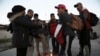Migrantes de diferentes naciones se reúnen cerca del muro fronterizo en Ciudad Juárez, México, el 21 de diciembre de 2022, al otro lado de la frontera desde El Paso, EEUU.