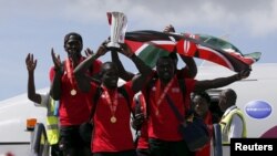 FILE: Kenya rugby 7's captain Andrew Amonde (C), flanked by Humphrey Khayange and Collins Injera (right), leads members of his team as they arrive after winning the HSBC Singapore Sevens in the Cup Final at the Jomo Kenyatta international airport in Nairobi. Taken April 19, 2016.