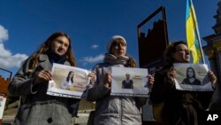 Члены Национального союза журналистов Украины держат плакаты с портретами трех журналисток, находящихся в российских тюрьмах: Ирины Данилович, Ирины Левченко и Виктории Рощиной.