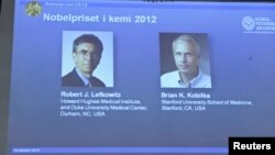 Images of researchers Robert Lefkowitz and Brian Kobilka (R) are seen on a projector during a news conference by the Royal Swedish Academy of Sciences in Stockholm, October 10, 2012. 