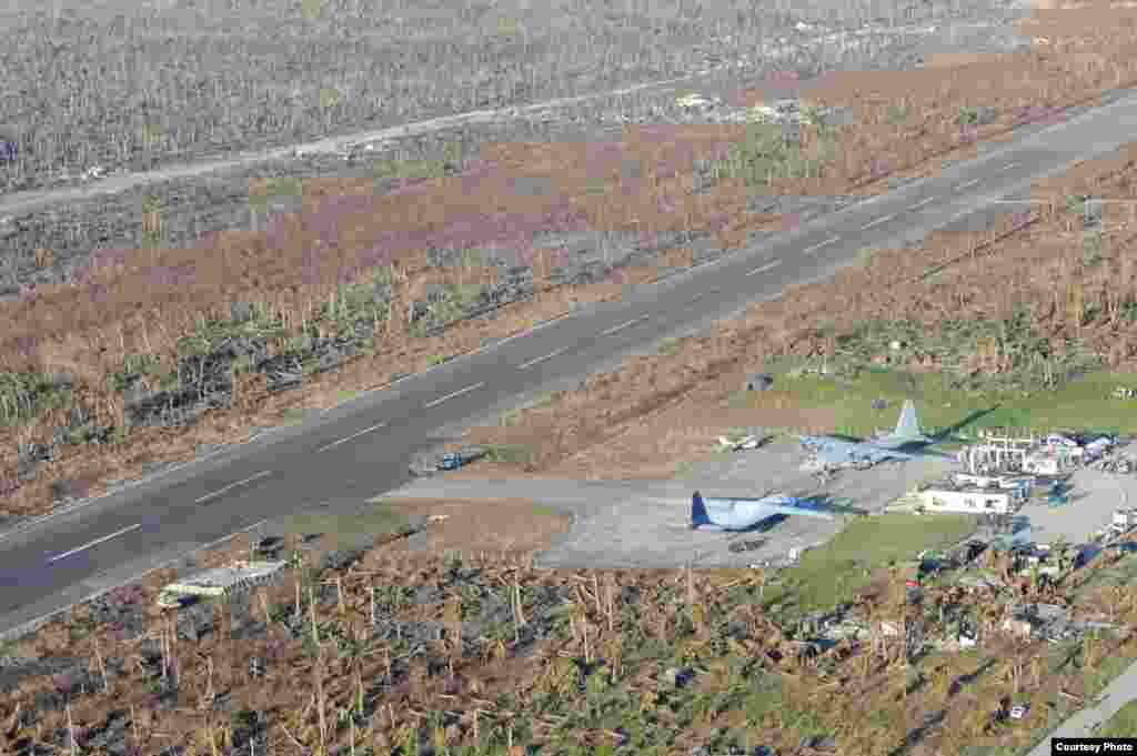 An HC-130 Hercules and other military aircraft sit on the tarmac at Guiuan airport waiting to airlift Philippine citizens in support of Operation Damayan. (US Navy)