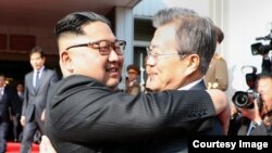 Presiden Korea Utara Kim Jong Un (kiri) dan Presiden Korea Selatan Moon Jae-in berpelukan pada pertemuan di Zona Demiliterisasi pada 26 Mei 2018. Foto dirilis oleh juru bicara Presiden Moon.