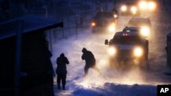 FILE - Cars line up at an exit ramp covered in snow in Cannon Ball, North Dakota, Dec. 6, 2016. Heavy snow, freezing rain and bitterly cold winds hit the state again Monday.