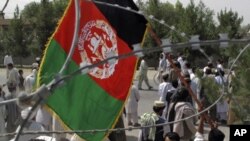 An Afghan man holds Afghanistan's flag during an anti-Pakistan protest in Helmand province, Afghanistan, July 11, 2011.