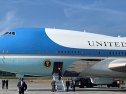 President Donald Trump, center, reboards Air Force One, after it stopped at Elmendorf Air Force Base near Anchorage, Alaska, on his way to the Group of 20 summit in Osaka, Japan, June 26, 2019.