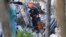 Fire rescue personnel conduct a search and rescue with dogs through the rubble of the Champlain Towers South Condo after the multistory building partially collapsed in Surfside, Fla., June 24, 2021. 