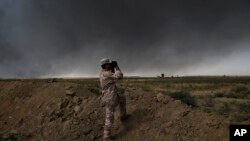 An Iraqi army member looks toward so-called Islamic State group territory outside Qayyarah on Tuesday Oct. 4, 2016.