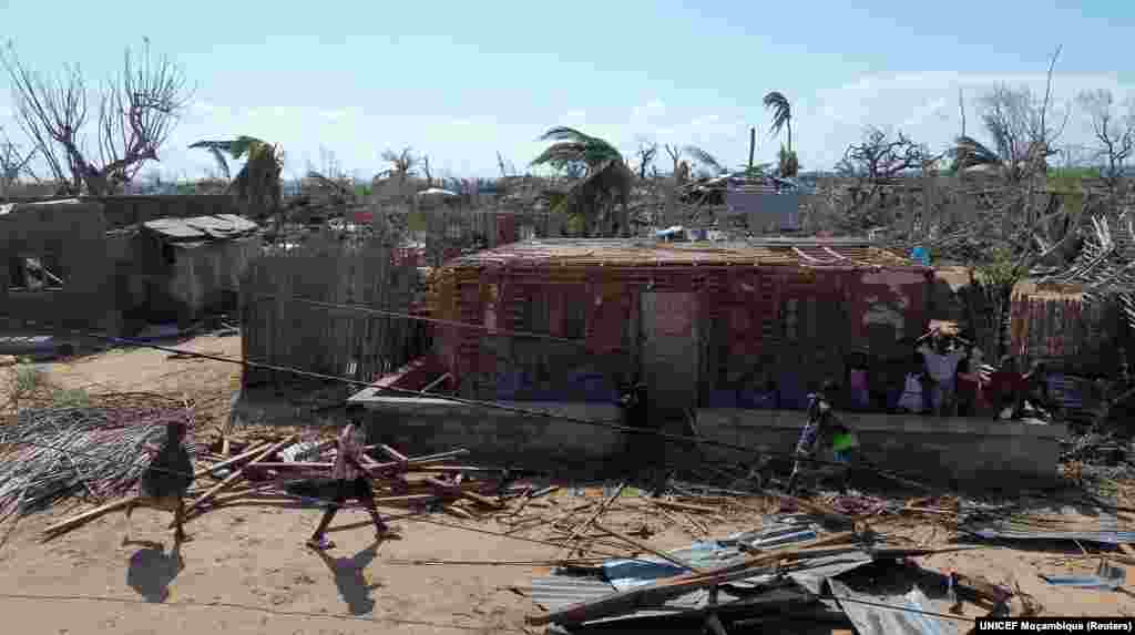 Crianças caminham ao lado de edifícios danificados e destruídos após a passagem do ciclone Chido no distrito de Mecufi, província de Cabo Delgado, Moçambique, a 16 de dezembro de 2024, nesta captura de ecrã retirada de um vídeo de um drone.