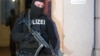 A German police officer stands outside a Berlin apartment building after a raid there against suspected jihadists, Jan. 16, 2014.