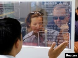 French tourists Isabelle and Marc Rigaud use an automated translation window at the Seibu-Shinjuku station in Tokyo, Japan, July 26, 2023. (REUTERS/Kim Kyung-Hoon)