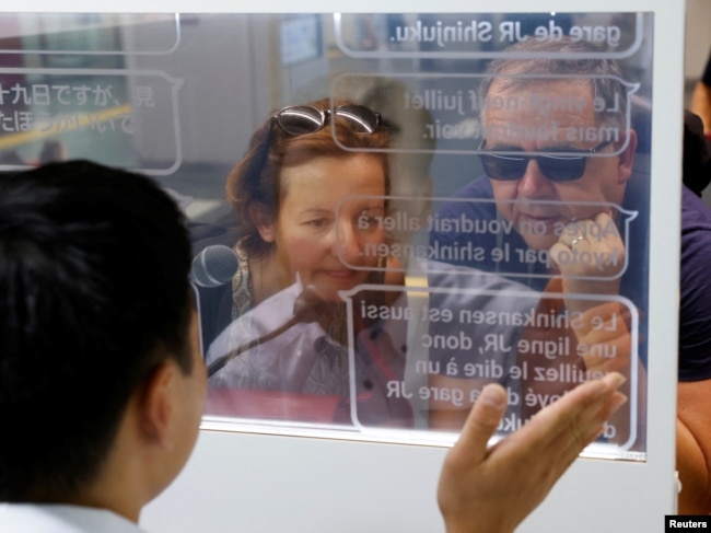 French tourists Isabelle and Marc Rigaud use an automated translation window at the Seibu-Shinjuku station in Tokyo, Japan, July 26, 2023. (REUTERS/Kim Kyung-Hoon)