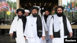 Members of a Taliban delegation, led by chief negotiator Mullah Abdul Ghani Baradar, center, leave after peace talks with Afghan senior politicians in Moscow, May 30, 2019.