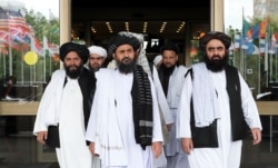 FILE - Members of a Taliban delegation, led by chief negotiator Mullah Abdul Ghani Baradar, center, leave after peace talks with Afghan senior politicians in Moscow, May 30, 2019.