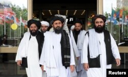 FILE - Members of a Taliban delegation, led by chief negotiator Mullah Abdul Ghani Baradar, center, leave after peace talks with Afghan senior politicians in Moscow, May 30, 2019.