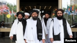 Members of a Taliban delegation, led by chief negotiator Mullah Abdul Ghani Baradar, center, leave after peace talks with Afghan senior politicians in Moscow, May 30, 2019.