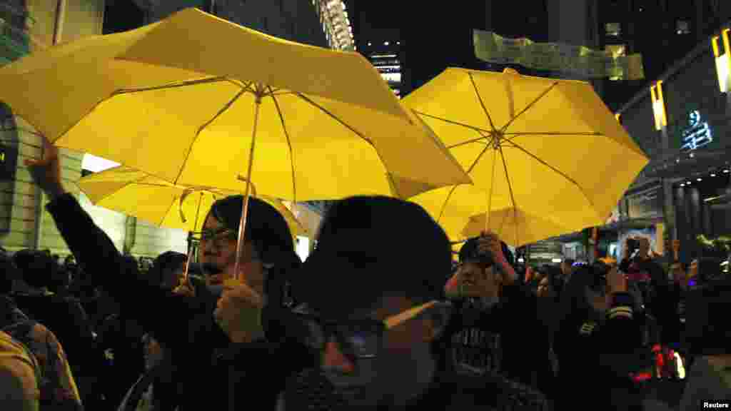 Pro-democracy revelers carrying yellow umbrellas, symbol of the Occupy movement, chant slogans among the celebrating crowds moments after a New Year countdown event in Hong Kong, Jan. 1, 2015. 