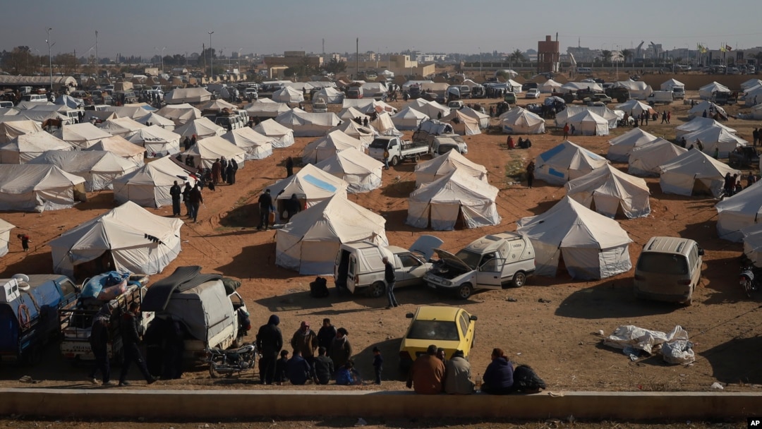 Internally displaced people walk among the tents in a camp in Tabqa city, Raqqa governorate, northern Syria, Dec. 4, 2024.