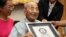 Yasutaro Koide, 112, receives the Guinness World Records certificate as he is formally recognized as the world's oldest man at a nursing home in Nagoya, central Japan, Aug. 21, 2015.