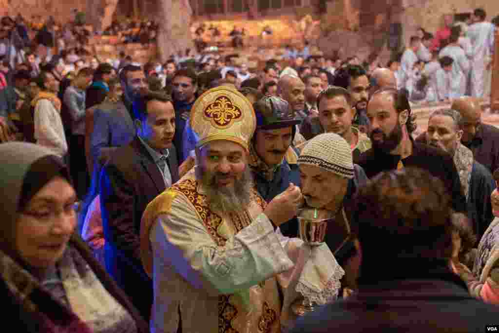 In Cairo&#39;s Manshiyat Naser ward, where a majority of residents are Coptic Christians, prayers are still held inside a poorly ventilated cave and sacraments are distributed to all with the same spoon. (H. Elrasam/VOA) 