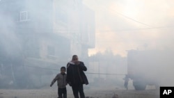 FILE - Palestinians run away after an Israeli strike on a residential building in Rafah, February 19, 2024.