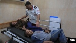 A Palestinian medical worker tends to children, members of a family where six were killed in an Israeli airstrike, in central Gaza Strip's Deir al-Balah, Nov. 14, 2019. 