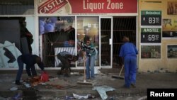 Les habitants nettoient après les manifestations à Coligny, Afrique du sud, le 26 avril 2017.