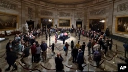 Los dolientes miran el ataúd cubierto con la bandera del expresidente Jimmy Carter mientras yace en el Capitolio, el martes 7 de enero de 2025, en Washington. 