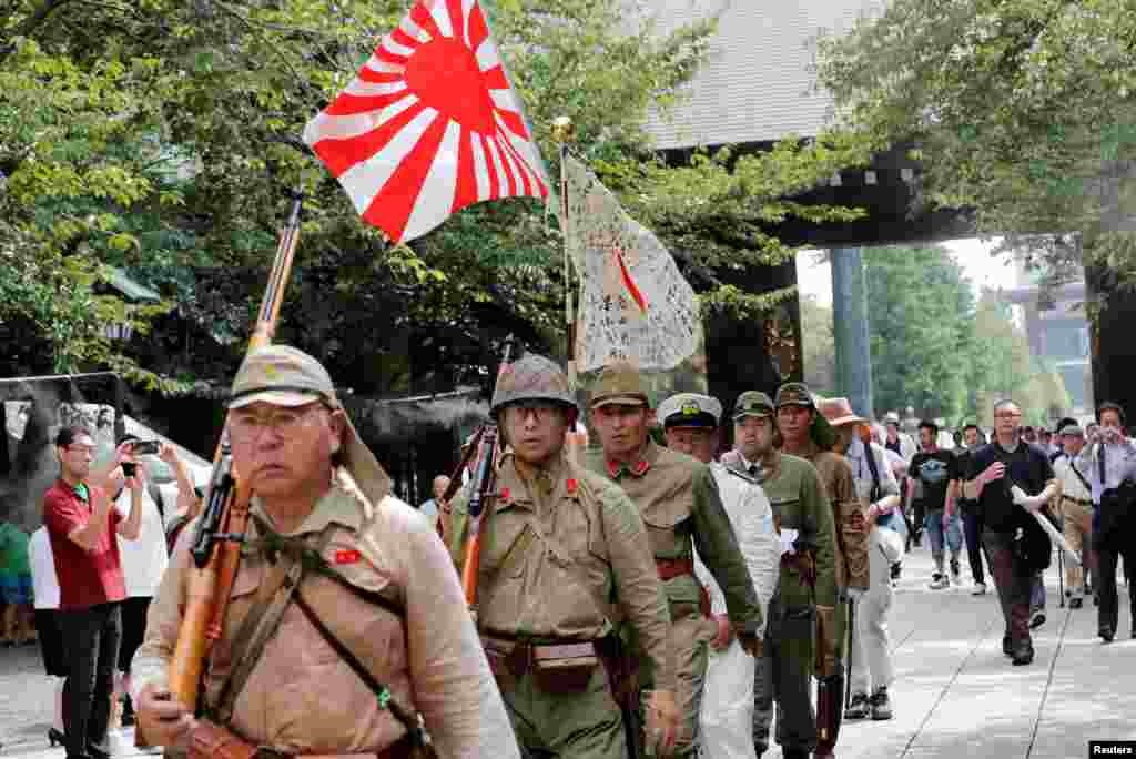 Men wearing the Japanese imperial military uniform visit the Yasukuni Shrine in Tokyo, Japan, on the 74th anniversary of the country&#39;s surrender in World War II.