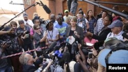 Anneliese Burgess, spokesperson for the family of South African Olympic and Paralympic sprinter Oscar Pistorius, reads a short statement outside the home of Pistorius' uncle Arnold in Pretoria, October 20, 2015. The family said on Tuesday they were "happ