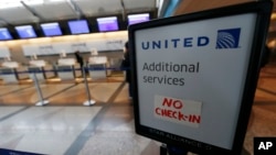 FILE - A piece of tape is affixed to a sign marking an empty line at the United Airlines ticket counter at Denver International Airport, April 16, 2016, in Denver, Colorado. United came under fire for having a passenger dragged off an overbooked flight at Chicago's O'Hare International Airport, April 9, 2017.