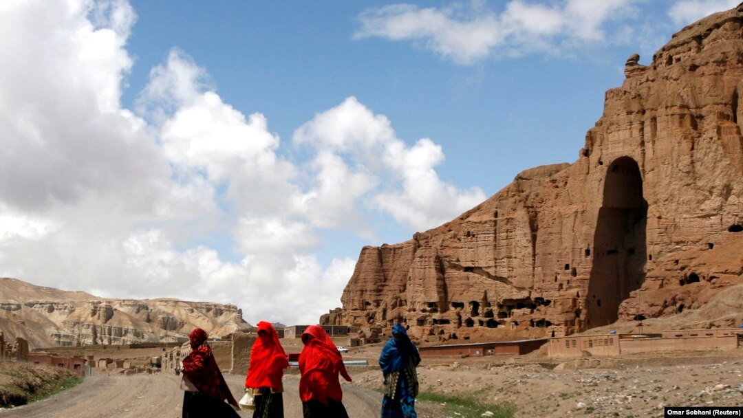 Perempuan Afghanistan berjalan di depan ceruk yang pernah terdapat patung Buddha raksasa, di Provinsi Bamiyan 21 April 2009. (Foto: REUTERS/Omar Sobhani)