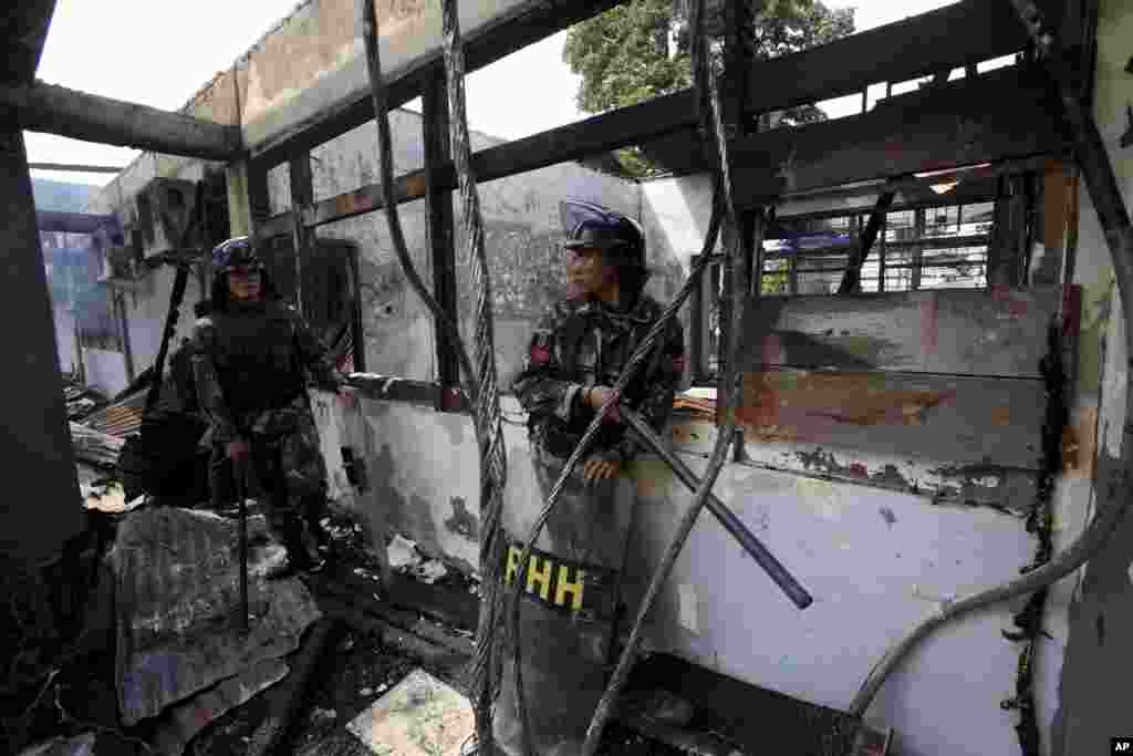 Indonesian soldiers stand guard in a burned down room at Tanjung Gusta prison following a riot in Medan, North Sumatra, Indonesia, July 12, 2013.&nbsp;