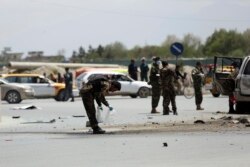 27일 아프가니스탄 카불에서 경찰들이 차량 폭탄 테러 사고가 발생한 현장을 조사하고 있다.