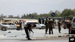 27일 아프가니스탄 카불에서 경찰들이 차량 폭탄 테러 사고가 발생한 현장을 조사하고 있다. 