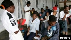 FILE - Cholera patients drink treated water inside an admission ward at Budiriro Polyclinic in Harare, Zimbabwe.