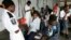 FILE - Cholera patients drink treated water inside an admission ward at Budiriro Polyclinic in Harare, Zimbabwe.