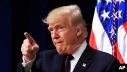 President Donald Trump acknowledges applause as speaks during a conference supporting veterans and military families through partnership at the Eisenhower Executive Office Building at the White House complex in Washington, Nov. 15, 2018. 