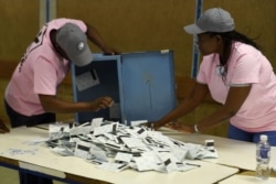 FILE - Polling officers verify ballots from ballot boxes arriving at a counting center in the Ledumang Senior Secondary school for the Gaborone North constituency, in Gaborone, Oct. 23, 2019.