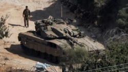 Seorang tentara Israel berdiri dekat tank di tengah bentrokan senjata antara Hizbullah dan Israel di utara Israel, 31 Oktober 2024. Kabinet Israel, Jumat, 1 November 2024, menyetujui anggaran 2025, termasuk kenaikan pajak untuk biayai perang. (Foto: Violeta Santos Moura/Reuters)