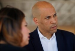 FILE - Democratic presidential candidate Sen. Cory Booker, right, speaks with Astrid Silva and others after a roundtable with Dreamers and immigrant activists, in Las Vegas, April 20, 2019.